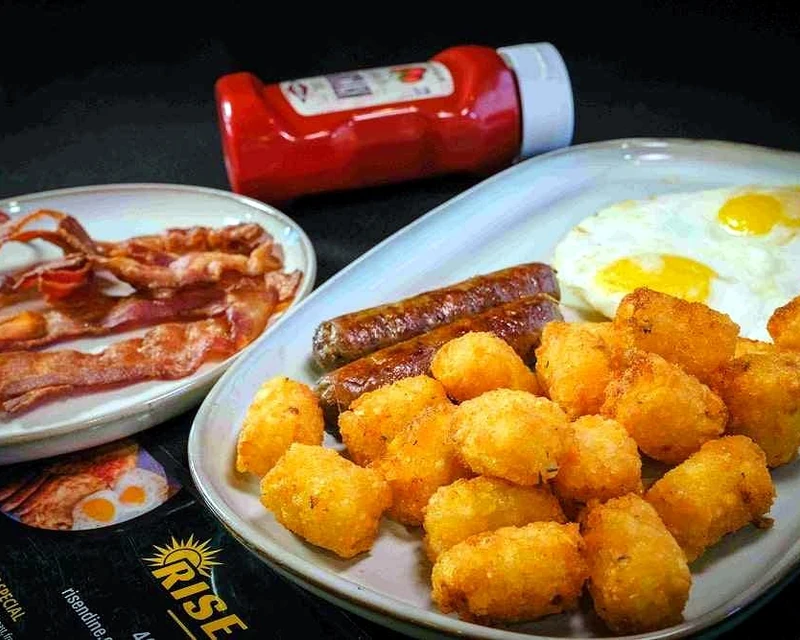 Breakfast plate with eggs, sausage and tater tots at Rise & Dine Restaurant